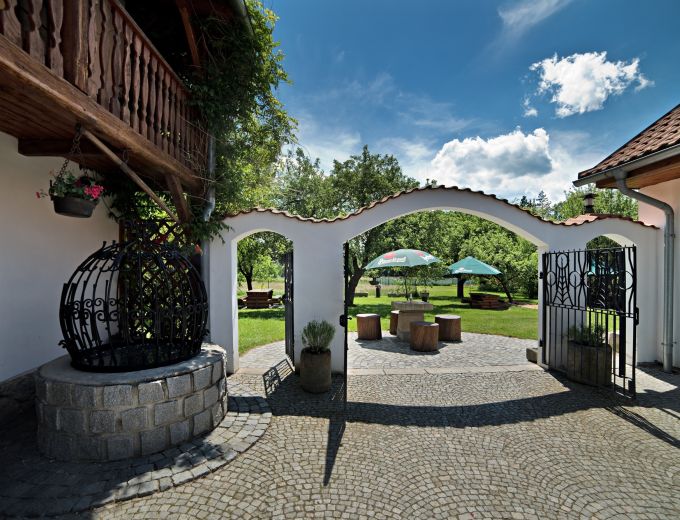 Pohled ze dvora na bránu do zahrady penzionu Kamínek v Nových Hradech